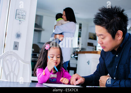 Mid adult père fille enfant enseignement dans la cuisine Banque D'Images