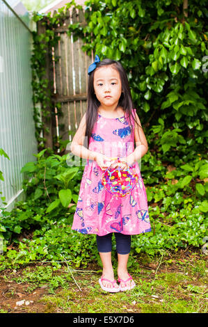 Portrait of young girl in garden with toy Banque D'Images