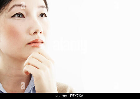 Close up portrait of young woman with hand on chin Banque D'Images