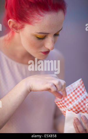 Jeune femme aux cheveux roses de manger de la nourriture à emporter Banque D'Images