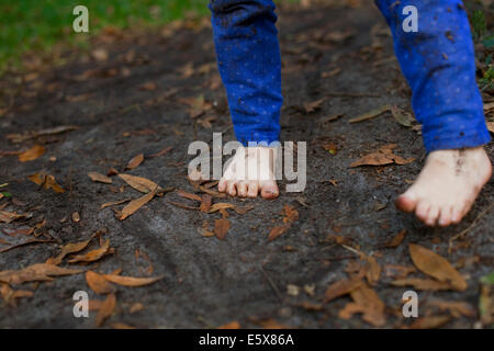 Pieds boueux de quatre ans, fille, debout dans la terre de jardin Banque D'Images