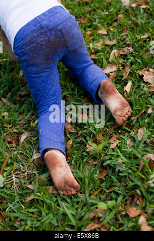 Quatre ans, fille, taille en bas de ramper sur l'herbe jardin Banque D'Images