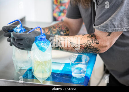 Tatoueur préparer son poste de travail avec les solutions antiseptiques Banque D'Images