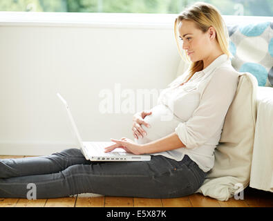 Pregnant woman using laptop computer Banque D'Images