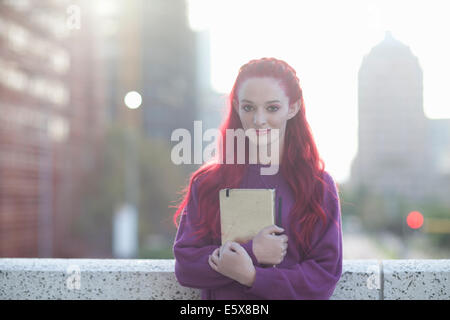 Portrait de jeune femme aux cheveux roses avec un ordinateur portable sur le toit de la ville Banque D'Images