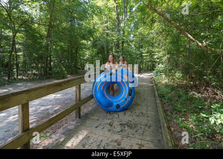 Les gens à pied jusqu'à l'un des points de départ pour tube en bas de la rivière Ichetucknee en Floride du Nord. Banque D'Images