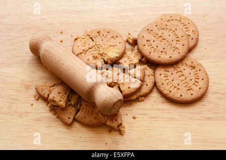 Ensemble et biscuits digestifs écrasé sur une planche avec un petit rouleau à pâtisserie en bois Banque D'Images