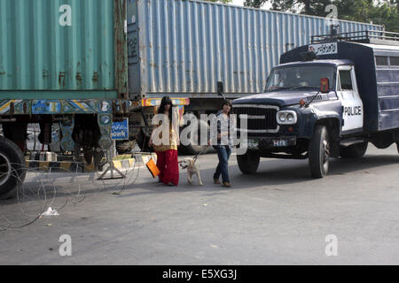 Lahore. 7e août, 2014. Les femmes pakistanaises traverser la route comme des conteneurs sont placés pour bloquer la zone près de la maison de l'érudit religieux Tahir-ul-Qadri avant de prochains rallye anti-gouvernement du Pakistan Tehreek Awami (PAT) dans l'est de Lahore au Pakistan le 7 août 2014. Tahir-ul-Qadri, a lancé la campagne contre Nawaz Sharif et a laissé entendre à rejoindre Khan en mars. La menace d'une manifestation nationale par le Tehrik-e-Insaf dirigé par cricketer-devenu politicien Imran Khan a mis la pression sur le gouvernement du Premier Ministre pakistanais Nawaz Sharif. © Jamil Ahmed/Xinhua/Alamy Live News Banque D'Images