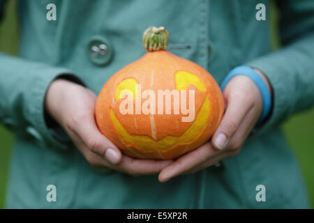 Halloween citrouille dans les mains des adolescents, photo gros plan Banque D'Images
