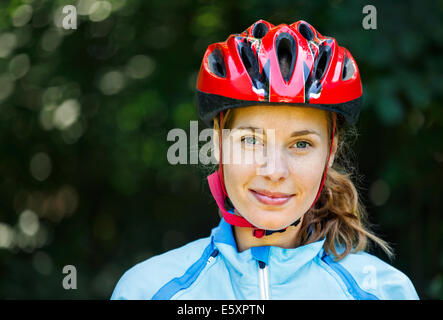 Portrait of happy young cyclist in sport vêtements et casque. Banque D'Images