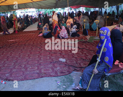 Lahore, Pakistan. 8e août, 2014. Les femmes activistes pakistanais du Pakistan Tehreek Awami (PAT) est titulaire d'baton comme elle s'assied à l'entrée où les femmes étudier en dehors de la chambre de clerc Tahir-ul-Qadri, avant une manifestation à Lahore.Tahir-ul-Qadri, a lancé la campagne contre Nawaz Sharif et a laissé entendre à rejoindre Khan en mars. La menace d'une manifestation nationale par le Tehrik-e-Insaf dirigé par cricketer-devenu politicien Imran Khan a mis la pression sur le gouvernement du Premier Ministre pakistanais Nawaz Sharif. Credit : Rana Sajid Hussain/Pacific Press/Alamy Live News Banque D'Images