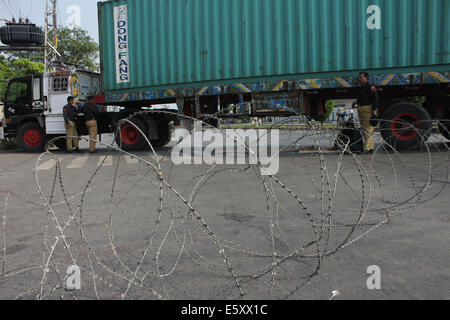 Lahore, Pakistan. 8e août, 2014. Cordon de policiers pakistanais de la région avec un camion conteneur avant une prochaine manifestation anti-gouvernement du Pakistan Tehreek Awami (PAT) à Lahore.Tahir-ul-Qadri, a lancé la campagne contre Nawaz Sharif et a laissé entendre à rejoindre Khan en mars. La menace d'une manifestation nationale par le Tehrik-e-Insaf dirigé par cricketer-devenu politicien Imran Khan a mis la pression sur le gouvernement du Premier Ministre pakistanais Nawaz Sharif. Credit : Rana Sajid Hussain/Pacific Press/Alamy Live News Banque D'Images