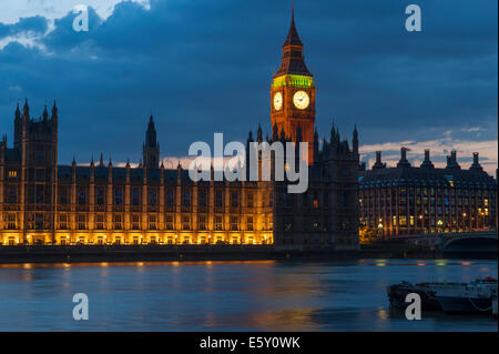 La tour de Big Ben après le coucher du soleil en été avec des lumières reflétées sur la Tamise. Banque D'Images