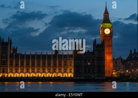 La tour de Big Ben après le coucher du soleil en été avec des lumières reflétées sur la Tamise. Banque D'Images