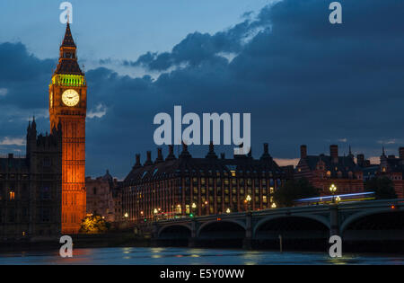 La tour de Big Ben après le coucher du soleil en été avec des lumières de Westminster Bridge reflétée sur la Tamise. Banque D'Images