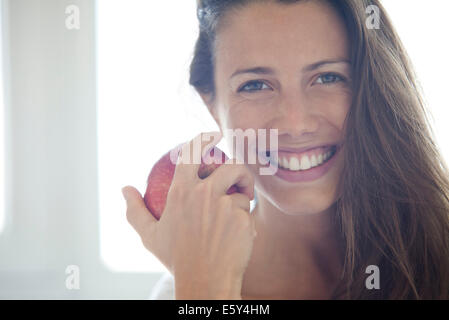 Woman holding apple, portrait Banque D'Images