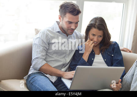 Couple using laptop computer together at home Banque D'Images