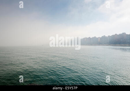 Brouillard de mer, près de la plage, avec des immeubles de grande hauteur en arrière-plan en été. Costa del Sol, Espagne. Banque D'Images