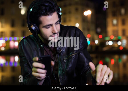 Jeune homme écoute de la musique avec des écouteurs Banque D'Images