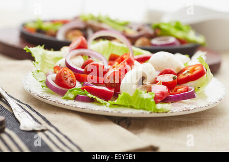 Dés de poulet cuit et saucisse avec oignons, poivrons, mushrrooms et une salade de tomates, champignons, poivrons et la laitue. Banque D'Images