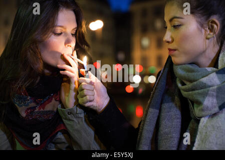 Femme de l'ami d'éclairage cigarette Banque D'Images