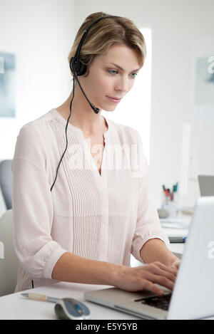 Office worker wearing casque de téléphone le multitâche Banque D'Images