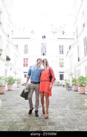 Couple en train de marcher ensemble en cour de construction Banque D'Images