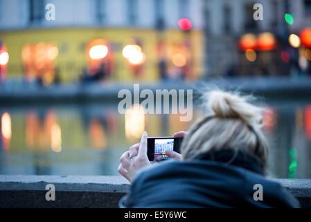 Woman using smartphone pour photographier la scène de la ville Banque D'Images