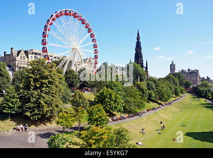 Grande Roue Ferris Festival & Scott Monument à East Princes Street Gardens Edinburgh Scotland avec les visiteurs bénéficiant d'ensoleillement Banque D'Images