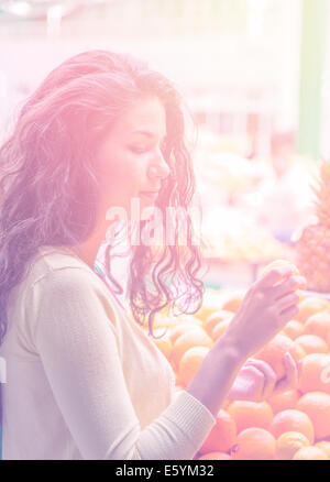 Jeune femme d'acheter des fruits au marché de la Banque D'Images