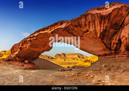 Voir à travers un rock arch dans le désert du Wadi Rum, Jordanie, Moyen-Orient Banque D'Images