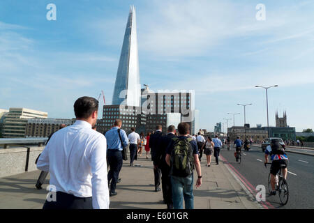 Ville d'homme d'affaires de London dans la foule d'employés de bureau à la maison sur le pont de Londres après le travail avec la vue de Shard Building London UK KATHY DEWITT Banque D'Images