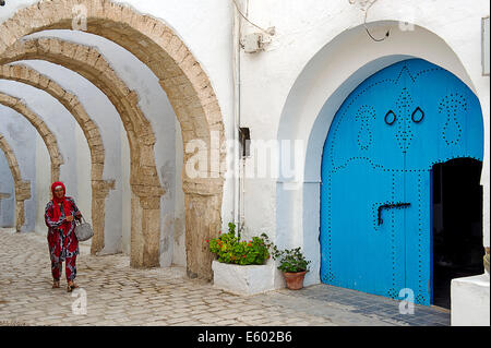 Afrique, Afrique du Nord, Maghreb, au sud de la Tunisie, l'île de Djerba. Governorat de Médenine. Houmt Souk. Une femme marche dans la médina. Banque D'Images