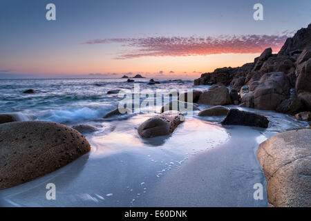 Tomber de vagues rochers arrondis Porth Nanven Cove au lit bébé en vallée près de Penzance en Cornouailles Banque D'Images