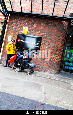 Femme parlant au téléphone avec bébé en poussette buggy Worcester Foregate Street station british rail line station en liaison Banque D'Images