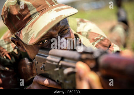 Un soldat a l'air bénin à travers les sites de son AK-47 au cours d'une classe de manipulation des armes détenues par des Marines américains le 9 octobre 2013 à Cotonou, Bénin. Banque D'Images