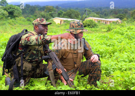Un soldat camerounais son relais situation à un conseiller de l'US Marine affecté à la Station 13 Partenariat avec l'Afrique, pendant une simulation dans le cadre d'un raid de l'engagement militaire du 29 octobre 2013 à Douala, Cameroun. Banque D'Images