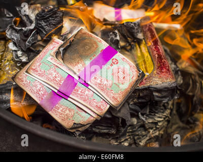 Bangkok, Thaïlande. 10e Août, 2014. Une pile de l'enfer de l'argent dans un baril de brûlage à Bangkok le premier jour du mois Ghost. L'enfer de l'argent est une forme de joss le papier imprimé pour ressembler à cours légal des billets de banque et est utilisé dans des cérémonies religieuses dans les communautés chinoises. Le septième mois de l'année lunaire chinoise est appelée ''Ghost'' mois pendant lequel les fantômes et les esprits, y compris ceux de l'ancêtres décédés, sortent de la sphère inférieure. Il est courant pour les Chinois de faire mérite au cours du mois par la combustion de ''l'enfer de l'argent'' et la présentation de la nourriture pour les fantômes. (Crédit Image : © Jack1977/ Banque D'Images