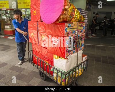 Bangkok, Thaïlande. 10e Août, 2014. Un volontaire pousse une charrette d'joss papier pour être brûlé dans un mois pour faire du mérite Ghost au Poh Teck Tung culte à Bangkok. Le septième mois de l'année lunaire chinoise est appelée ''Ghost'' mois pendant lequel les fantômes et les esprits, y compris ceux de l'ancêtres décédés, sortent de la sphère inférieure. Il est courant pour les Chinois de faire mérite au cours du mois par la combustion de ''l'enfer de l'argent'' et la présentation de la nourriture pour les fantômes. Crédit : Jack Kurtz/ZUMA/Alamy Fil Live News Banque D'Images