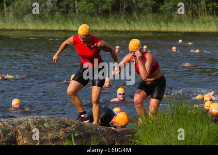 Les gens participant à un swimrun Ångaloppet, compétition où vous exécutez sur terre et se baigner dans les lacs et la mer à plusieurs reprises. Banque D'Images