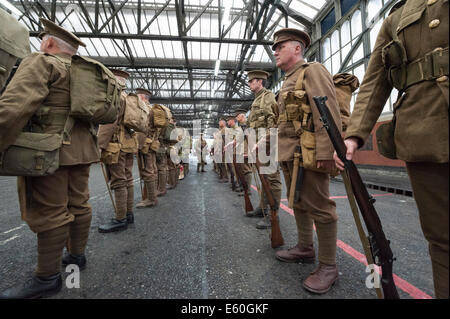 La gare de Waterloo, Londres, Royaume-Uni. 10 août 2014. Les chums de kaki, un régiment d'historiens, a adopté de nouveau le voyage de WW1 soldats arrivant à la gare de Waterloo à Londres, dormir sur la terre la nuit avant le départ sur un train à destination de Southampton. Le régiment a effectué une marche à travers la station de rendre hommage à ceux qui se sont tenus à leur place il y a un siècle. La reconstitution a été le cadre du lancement d'une exposition expliquant le rôle vital de fer britanniques et ont joué dans la Grande Guerre. Credit : Lee Thomas/Alamy Live News Banque D'Images