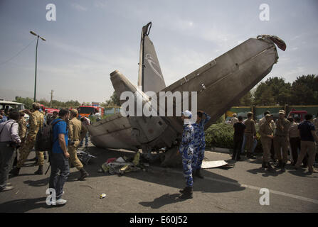 Téhéran, Iran. 10e Août, 2014. Deux membres de l'Iran's air force montent la garde en face de l'épave d'Iran-140 Sepahan avion de passagers de l'air sur le site de l'écrasement près de l'aéroport Mehrabad de Téhéran de l'ouest. Au moins 38 personnes ont été tuées, mais d'autres ont survécu quand le petit avion s'est écrasé près de la capitale iranienne, de l'état des médias. Credit : ZUMA Press, Inc./Alamy Live News Banque D'Images