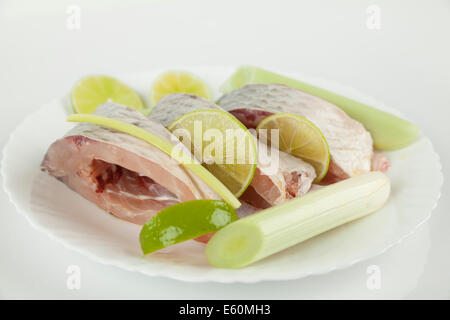 Poisson carpe sur plaque blanche avec limeta et l'oignon Banque D'Images