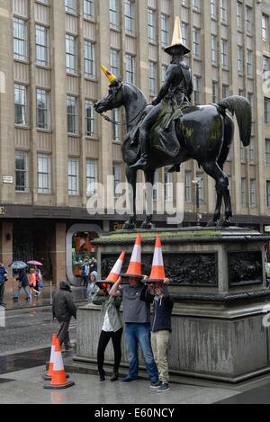 La statue de Wellington à Glasgow, l'Écosse, orné de cône de trafic avec les touristes de la copie et de prendre des photos. Banque D'Images