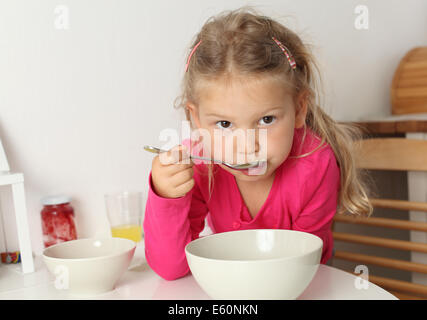 Cute quatre ans, fille mange de la soupe à la maison Banque D'Images