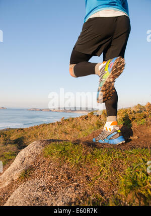 L'homme pratiquant le trail running et sauter en plein air Banque D'Images