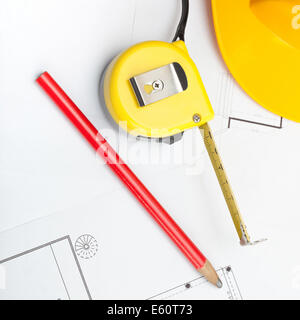 Construction jaune casque avec crayon et mesurer ruban sur certains documents - 1 à 1 Banque D'Images