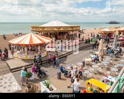 Une foule de vacanciers jolly profitez d'une promenade le long du front de mer de Brighton et de la promenade avec fête foraine attractions et boutiques de souvenirs Banque D'Images