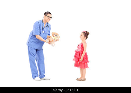 Médecin donnant un ours d'une petite fille surprise Banque D'Images