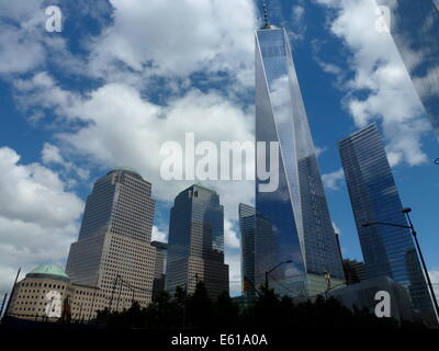 Miroir nuages sur la façade de One World Trade Center (WTC 1) bureau highrise, précédemment connu sous le nom de la tour de la liberté, situé à côté du World Financial Center (WFC) (L) à New York City, USA, 20 juin 2014. Le WTC 1 gratte-ciel a été construit sur le site également connu sous le nom de Ground Zero, qui a vu la destruction du World Trade Center à l'attaque terroriste du 11 septembre 2001. Le bâtiment qui est en construction depuis 2006 est la plus haute construite dans le United States, mesure 541,3 mètres. Photo : Alexandra Schuler/DPA - PAS DE FILS DE SERVICE - Banque D'Images